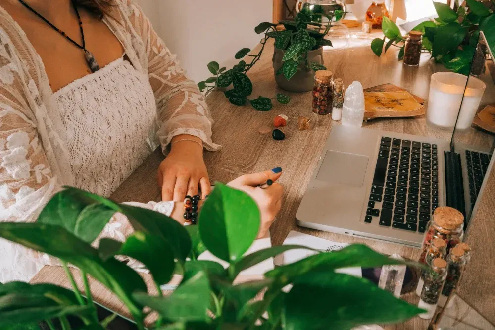 Woman working at home office desk with a clear quartz tower to her left