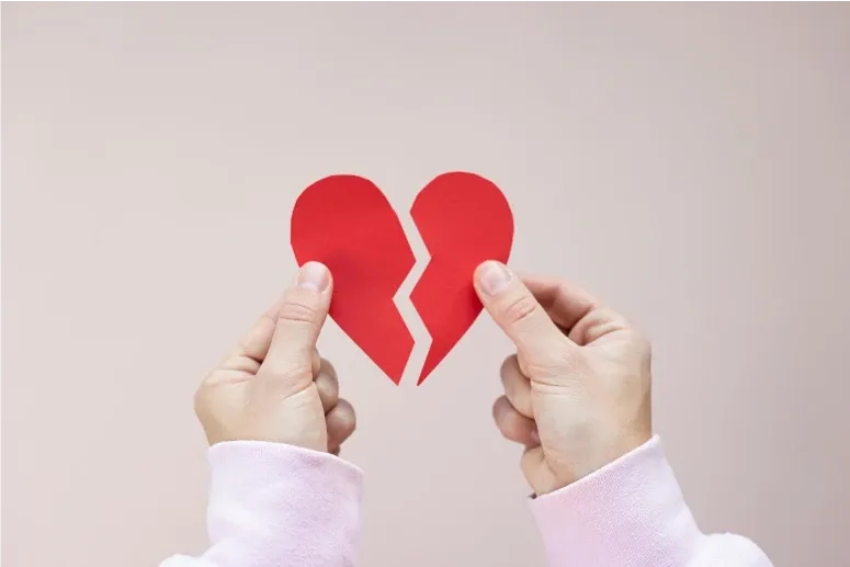 Shattered red paper heart representing emotional healing and heartbreak